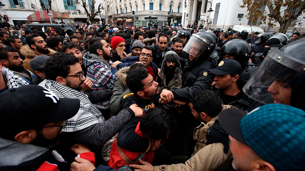 Manifestantes tunecinos se enfrentan a la policía durante una protesta en contra de la política económica del Gobierno