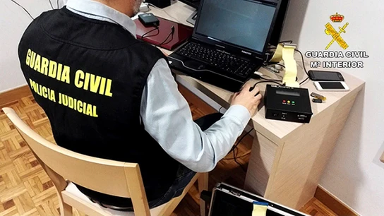 Un guardia civil analizando delitos de pornografía infantil Fotografía facilitada por la Guardia Civil, que ha detenido a cuatro personas y ha investigado a otras dos como presuntas autoras de delitos de pornografía infantil, agresión sexual y abuso sexual a menores