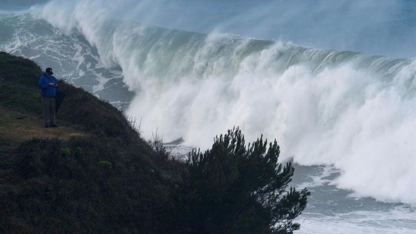 Un hombre fotograf&iacute;a las grandes olas que rompen ayer en la costa de la capital c&aacute;ntabra