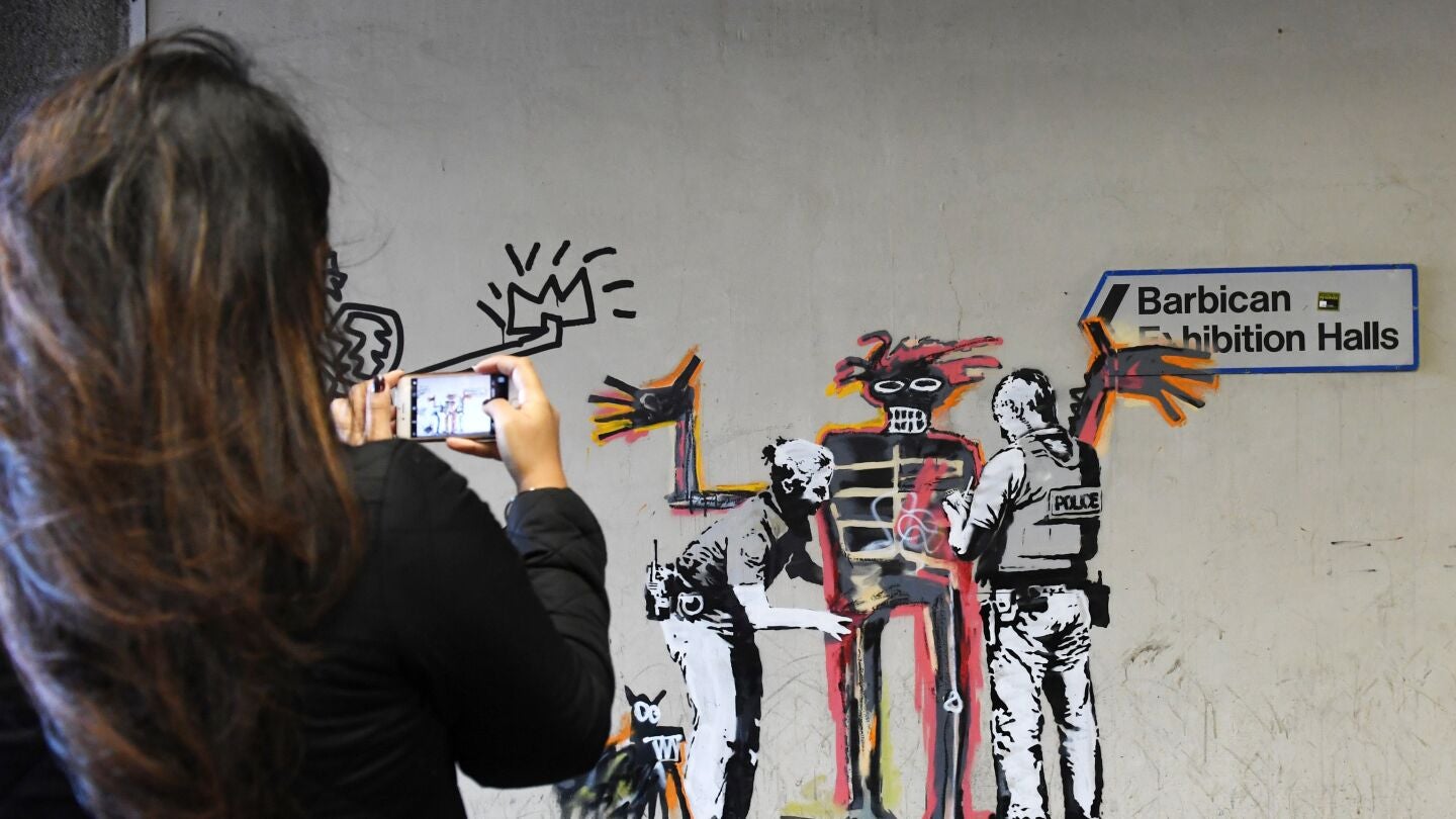 Ciudadanos toman fotograf&iacute;as de una obra del artista Banksy en Londres (Reino Unido)