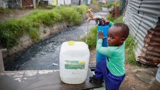 Un niño llenando una garrafa de agua en Ciudad del Cabo Un niño llenando una garrafa de agua en Ciudad del Cabo
