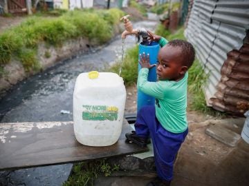 Un niño llenando una garrafa de agua en Ciudad del Cabo Un niño llenando una garrafa de agua en Ciudad del Cabo
