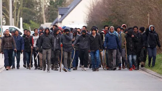 Un grupo de inmigrantes carga palos y piedras durante un enfrentamiento cerca del puerto de Calais Un grupo de inmigrantes carga palos y piedras durante un enfrentamiento cerca del puerto de Calais