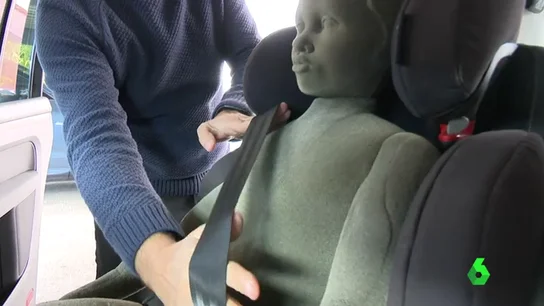 Un técnico realiza una demostración de los riesgos de usar abrigo en la silla del coche Un técnico realiza una demostración de los riesgos de usar abrigo en la silla del coche