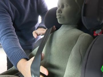 Un técnico realiza una demostración de los riesgos de usar abrigo en la silla del coche Un técnico realiza una demostración de los riesgos de usar abrigo en la silla del coche