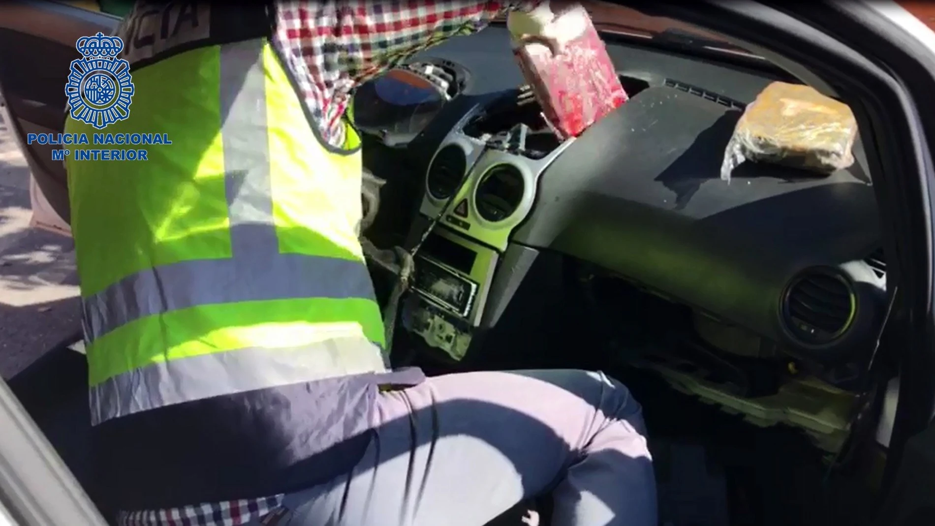 Un agente revisa el salpicadero de un coche en busca de droga