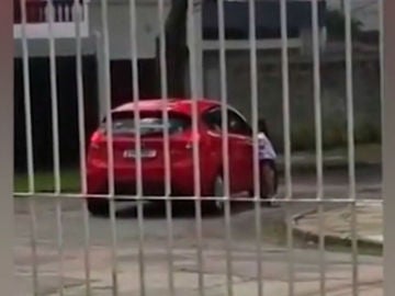 Una niña grita desconsolada para que su madre le deje subir al coche Una niña grita desconsolada para que su madre le deje subir al coche
