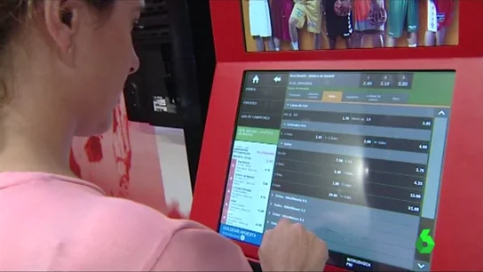 Una mujer usa una máquina de apuestas Una mujer usa una máquina de apuestas