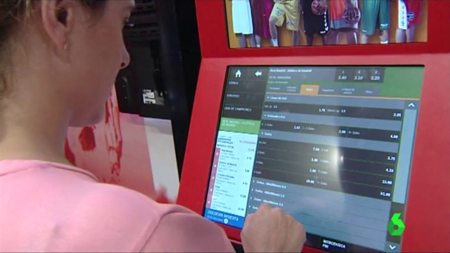 Una mujer usa una m&aacute;quina de apuestas