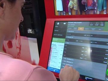 Una mujer usa una máquina de apuestas Una mujer usa una máquina de apuestas