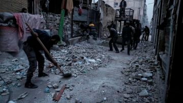 Un hombre quita los escombros tras un bombardeo cerca de Damasco