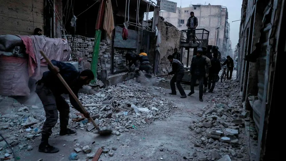 Un hombre quita los escombros tras un bombardeo cerca de Damasco