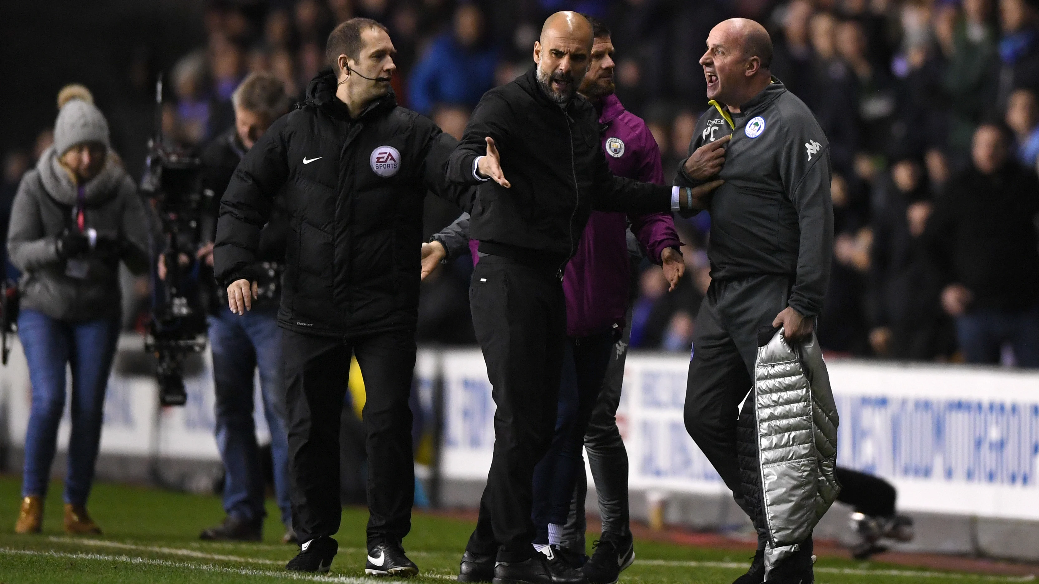 Guardiola discute con Paul Cook, técnico del Wigan Guardiola discute con Paul Cook, técnico del Wigan