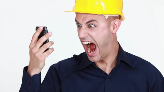 Un obrero gritando por teléfono Un obrero gritando por teléfono