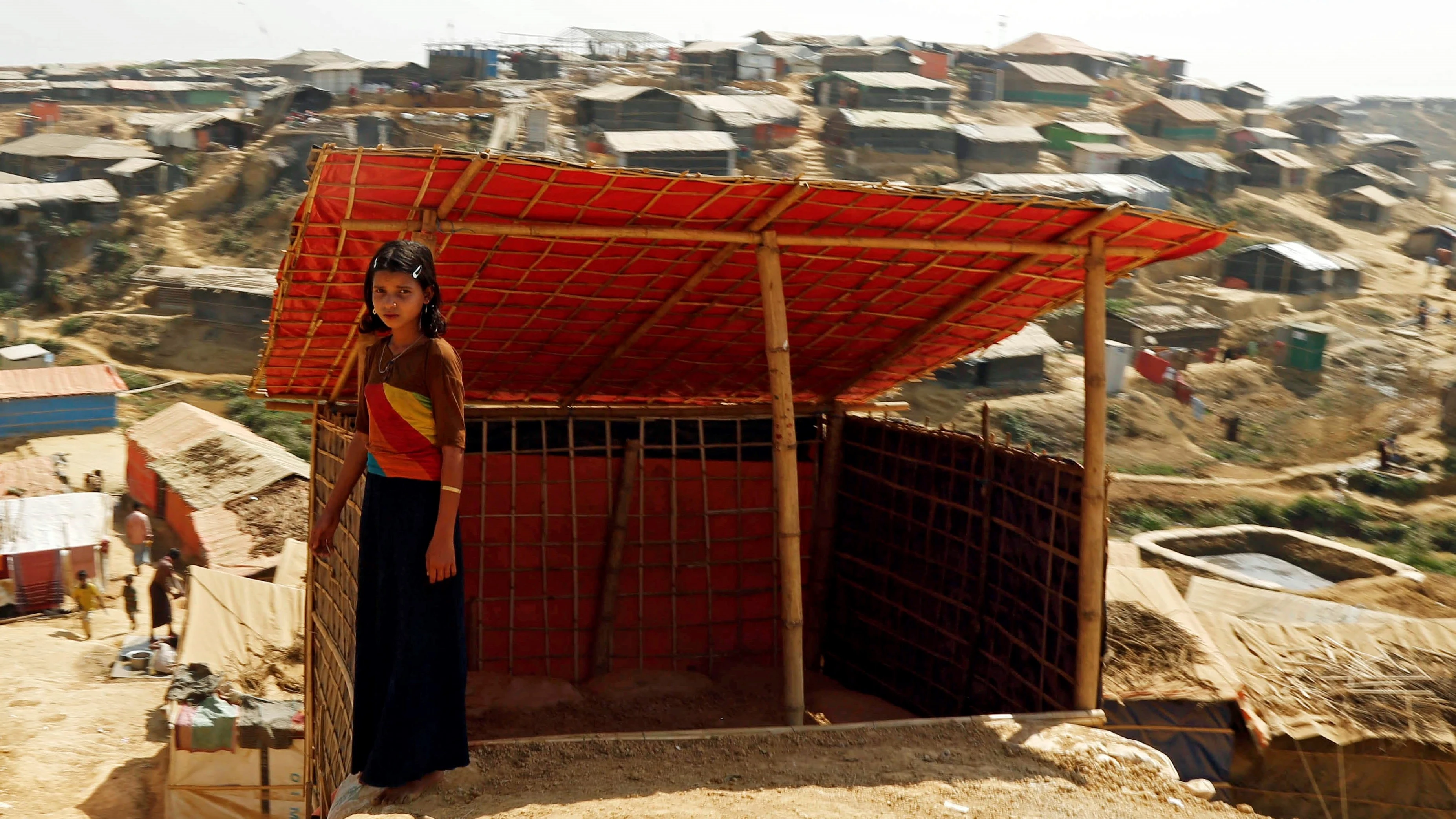 Una niña rohinyá posa delante de su tienda en un campamento en Bangladesh