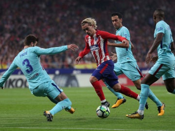 Griezmann intenta avanzar ante la defensa del Barcelona