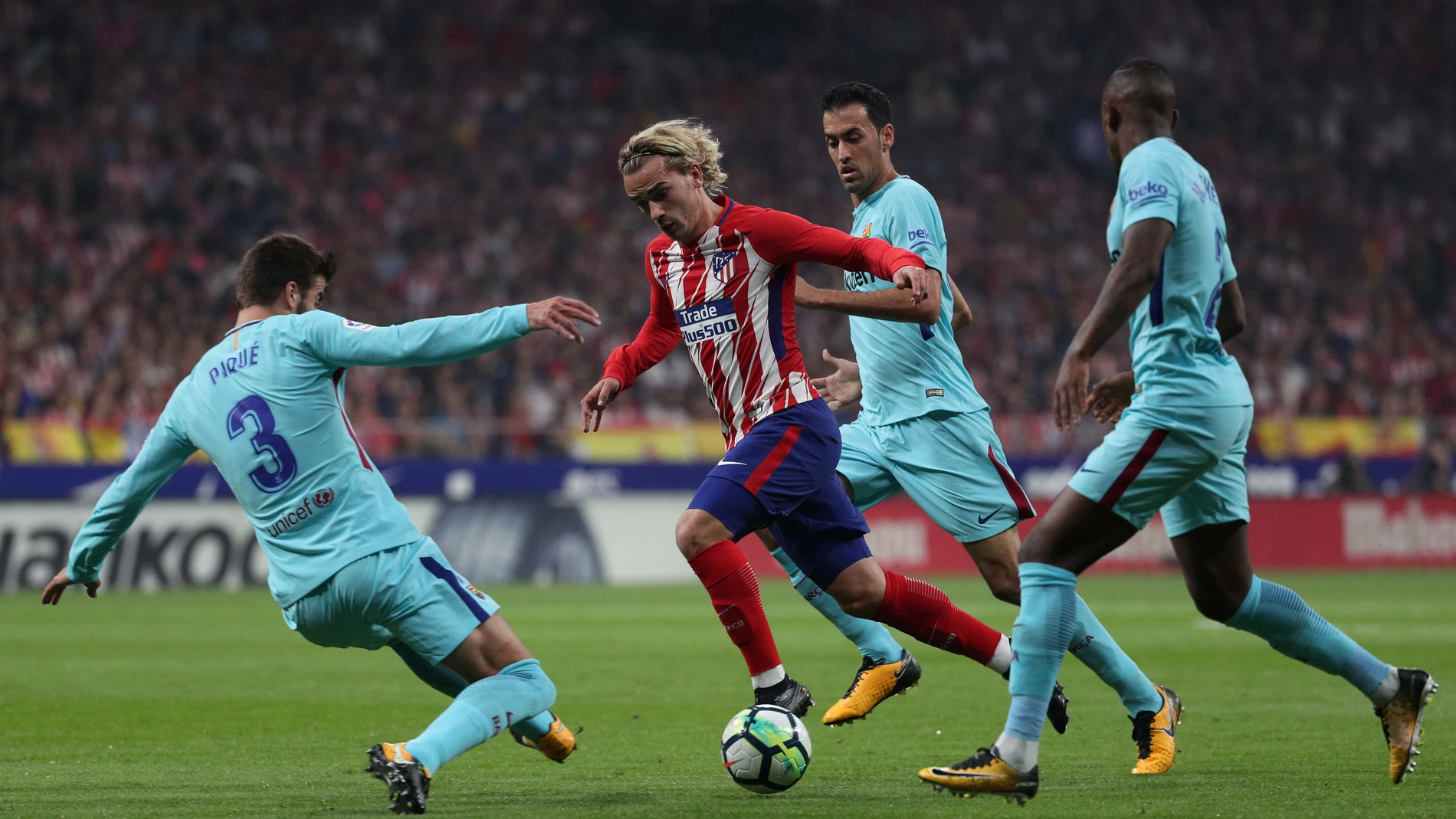 Griezmann intenta avanzar ante la defensa del Barcelona