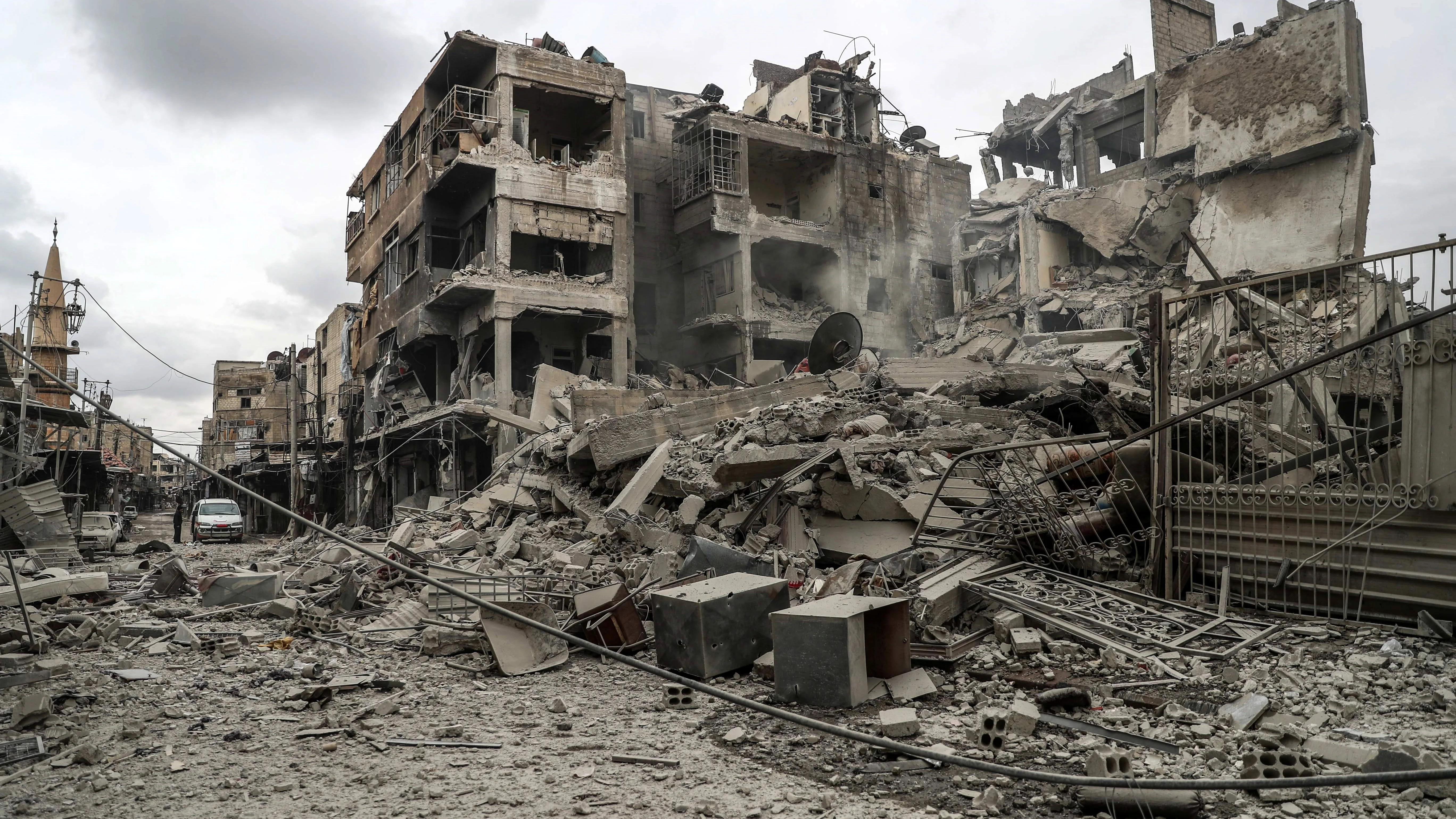 Vista de la calle y edificios en ruinas después de varios bombardeos, en Duma, feudo rebelde de Guta Oriental 