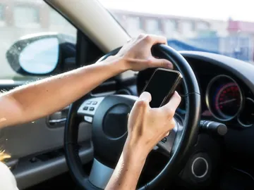 Imagen de un conductor utilizando el móvil al volante. Imagen de un conductor utilizando el móvil al volante.