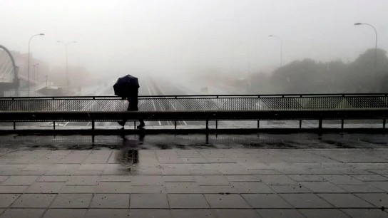Un transeúnte pasa por un puente de la autopista TF-5 Un transeúnte pasa por un puente de la autopista TF-5