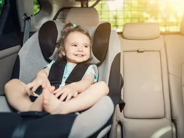 Una niña en su sillita infantil Una niña en su sillita infantil