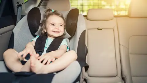Una niña en su sillita infantil Una niña en su sillita infantil