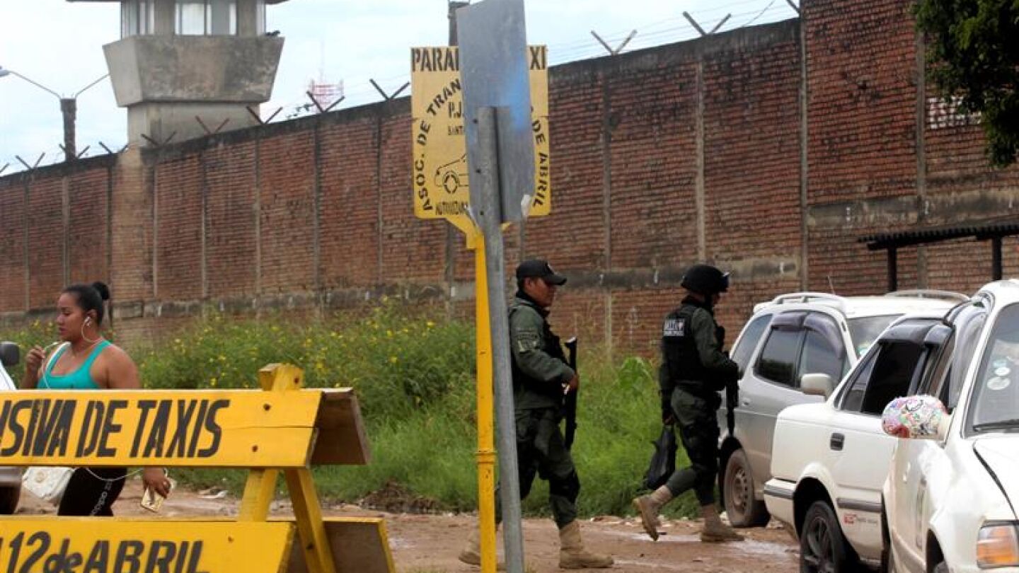 Dos polic&iacute;as caminan junto a la c&aacute;rcel de Palmasola, en Bolivia