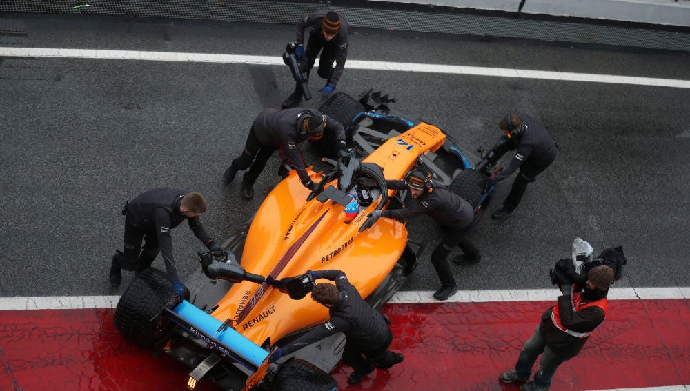 Los mecánicos de McLaren meten el monoplaza de Alonso a boxes