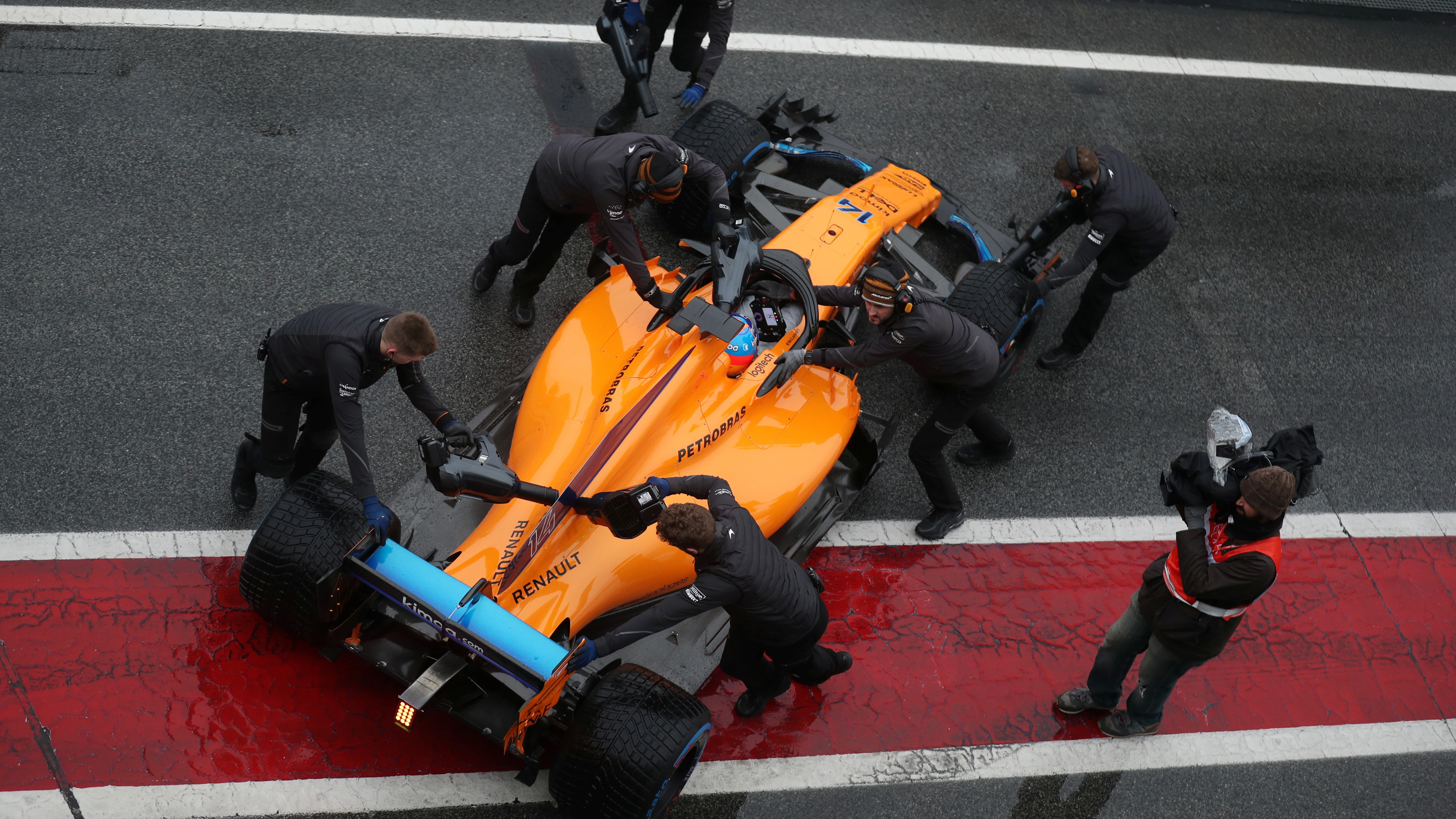 Los mecánicos de McLaren meten el monoplaza de Alonso a boxes