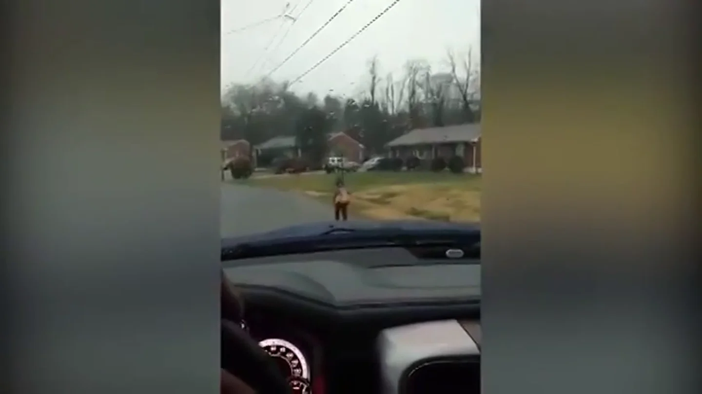 Un padre hace que su hijo vaya corriendo al colegio bajo la lluvia Un padre hace que su hijo vaya corriendo al colegio bajo la lluvia