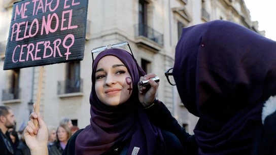 Dos mujeres se pintan el símbolo femenino en la cara durante la manifestación feminista del 8M en Valencia Dos mujeres se pintan el símbolo femenino en la cara durante la manifestación feminista del 8M en Valencia