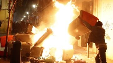 Contenedores incendiados en la calle Mesón de Paredes con la calle del Oso