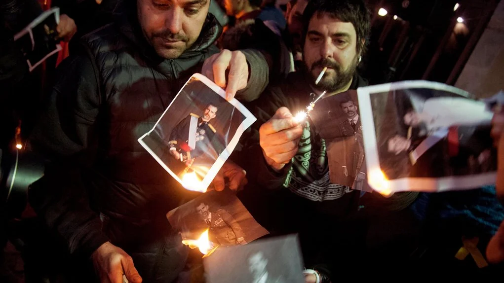 Varias personas quemando fotos del rey en Girona