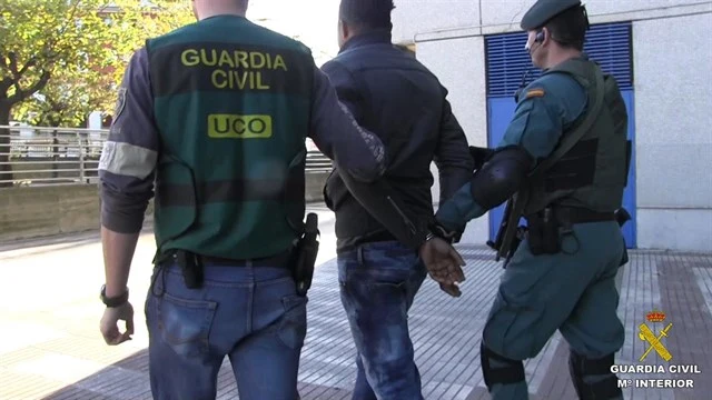 Agentes de la Guardia Civil con uno de los detenidos