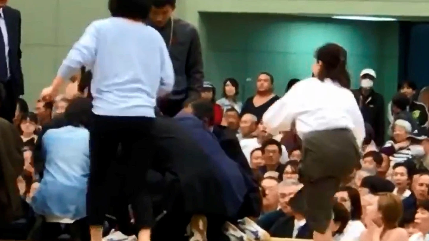 Varias mujeres tratan de reanimar a un hombre desfallecido en un ring de sumo Varias mujeres tratan de reanimar a un hombre desfallecido en un ring de sumo