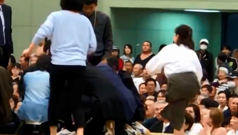 Varias mujeres tratan de reanimar a un hombre desfallecido en un ring de sumo