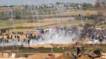 Palestinos huyen de las bombas de gas lacrimógeno lanzadas por tropas israelíes 