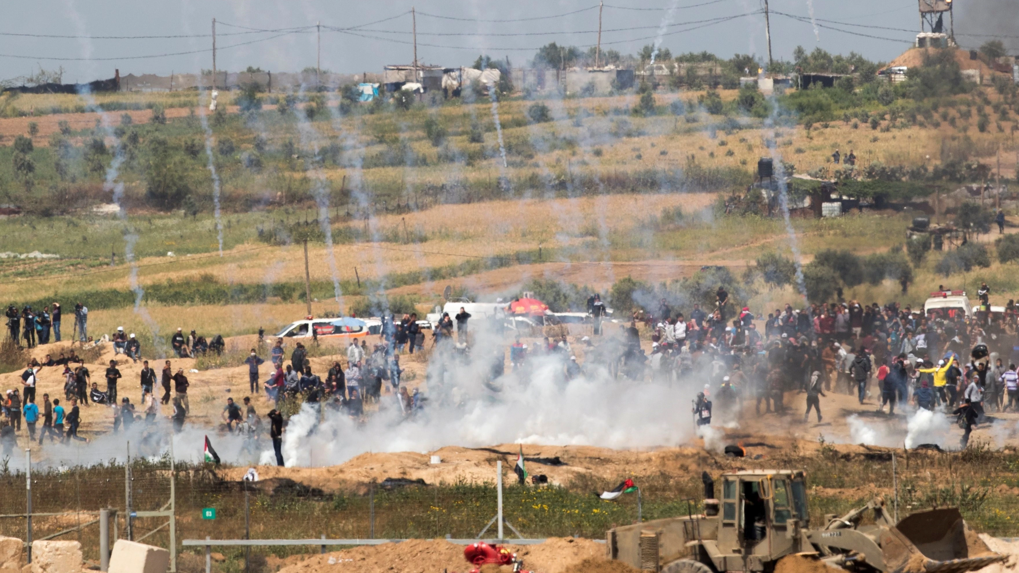 Palestinos huyen de las bombas de gas lacrimógeno lanzadas por tropas israelíes 