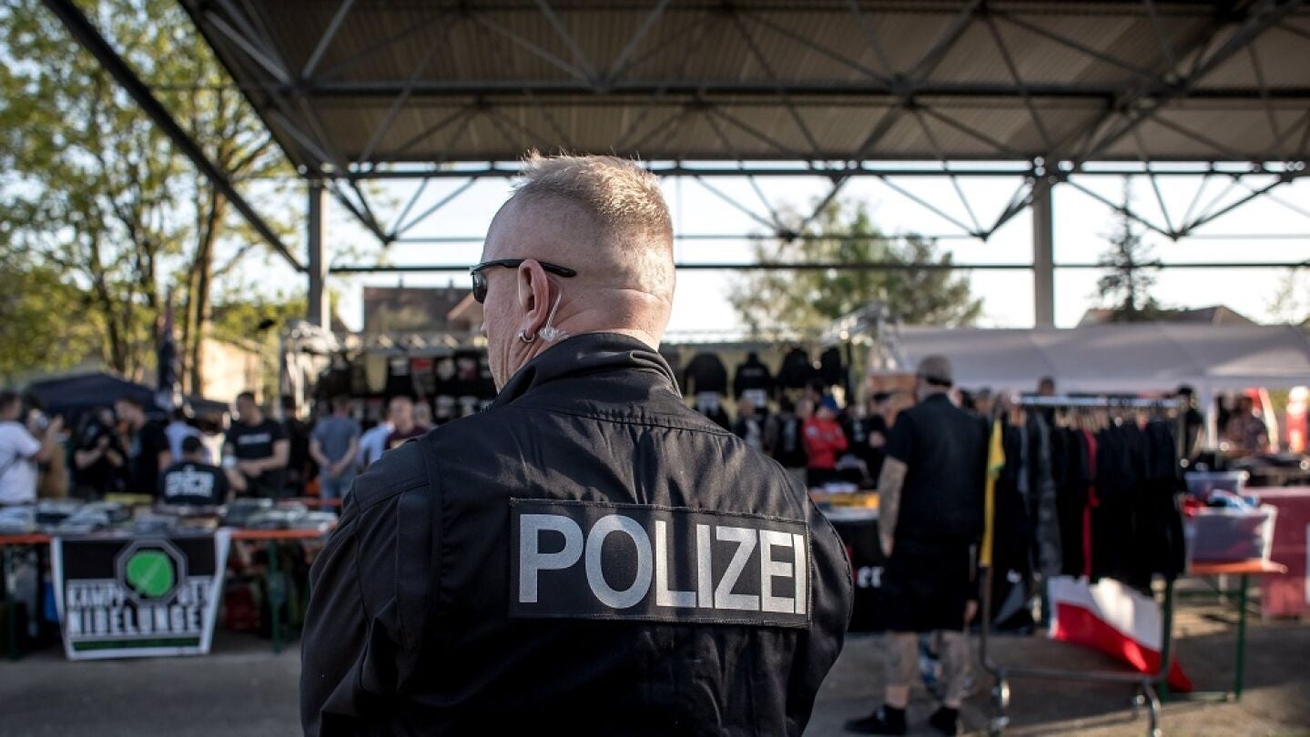  Un polic&iacute;a vigila a los participantes del festival neonazi.