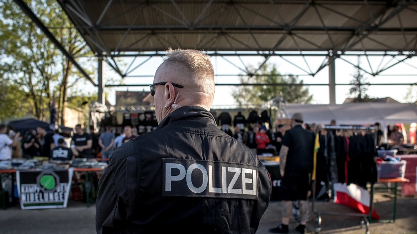 Un policía vigila a los participantes del festival neonazi. Un policía vigila a los participantes del festival neonazi.