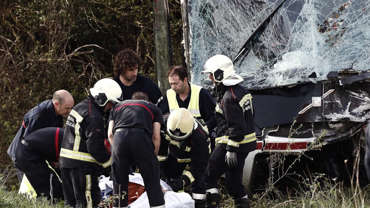 Un grupo de bomberos y m&eacute;dicos atienden a los heridos