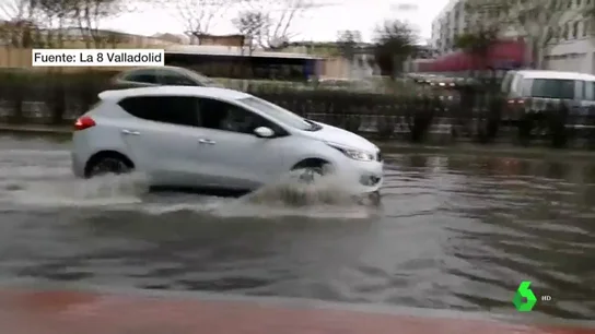 Un coche para por un charco en Valladolid Fuerte tormenta en Valladolid que contrasta con temperaturas veraniegas en Valencia