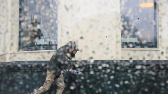 Imagen de archivo de un hombre intentando resguardarse de una tormenta Imagen de archivo de un hombre intentando resguardarse de una tormenta