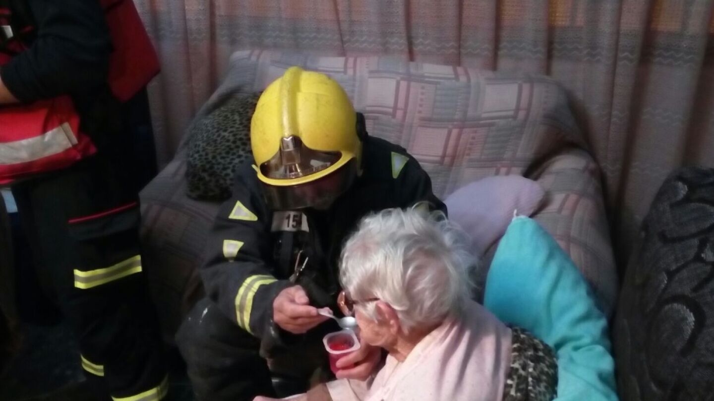 Bomberos dando un yogur a la anciana que pas&oacute; varias horas en el suelo