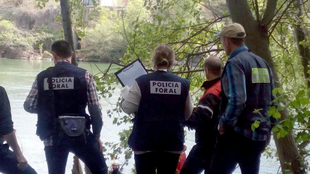 Fotografía facilitada por la Policía Foral de los agentes y miembros del cuerpo de bomberos durante las labores de rescate del cadáver 