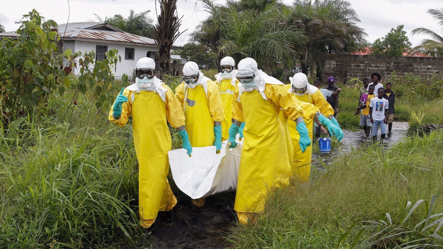 Enfermeros trasladas el cuerpo de una supuesta v&iacute;ctima del virus &eacute;bola en un &aacute;rea a las afueras de Monrovia (Liberia)
