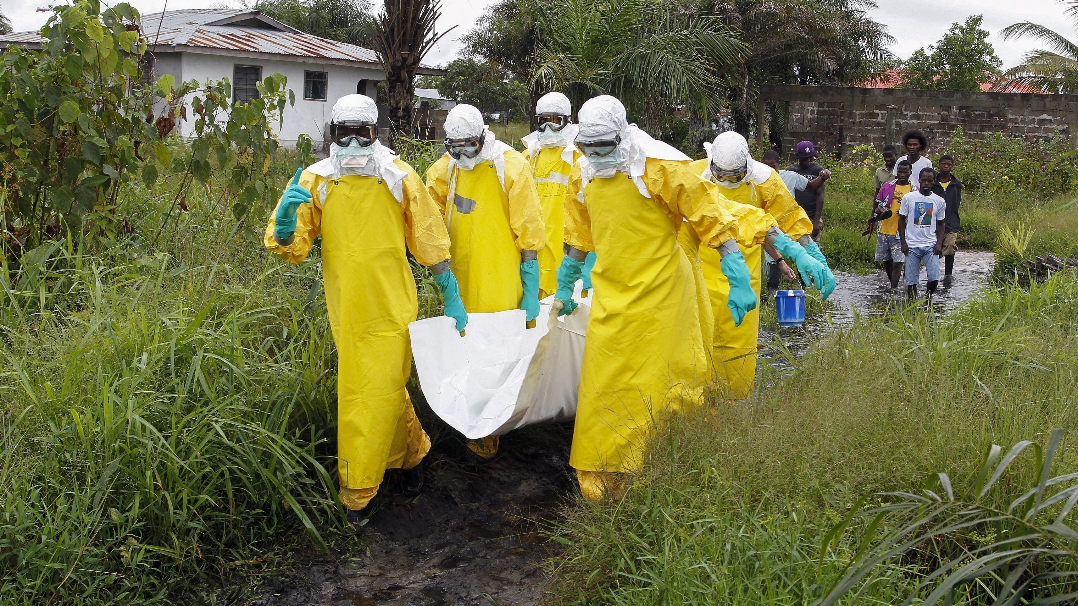 Enfermeros trasladas el cuerpo de una supuesta víctima del virus ébola en un área a las afueras de Monrovia (Liberia)