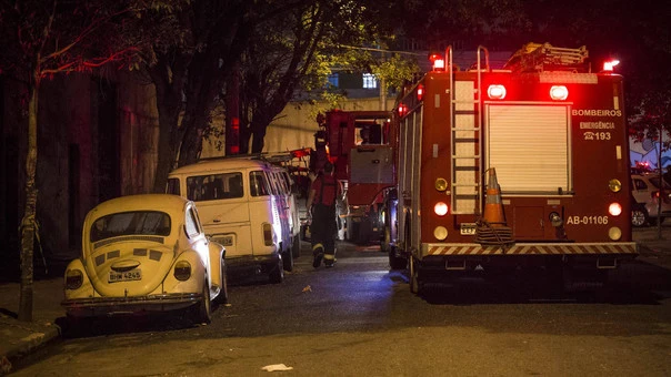 Coche de los bomberos estacionado cerca del almacén que se incendió