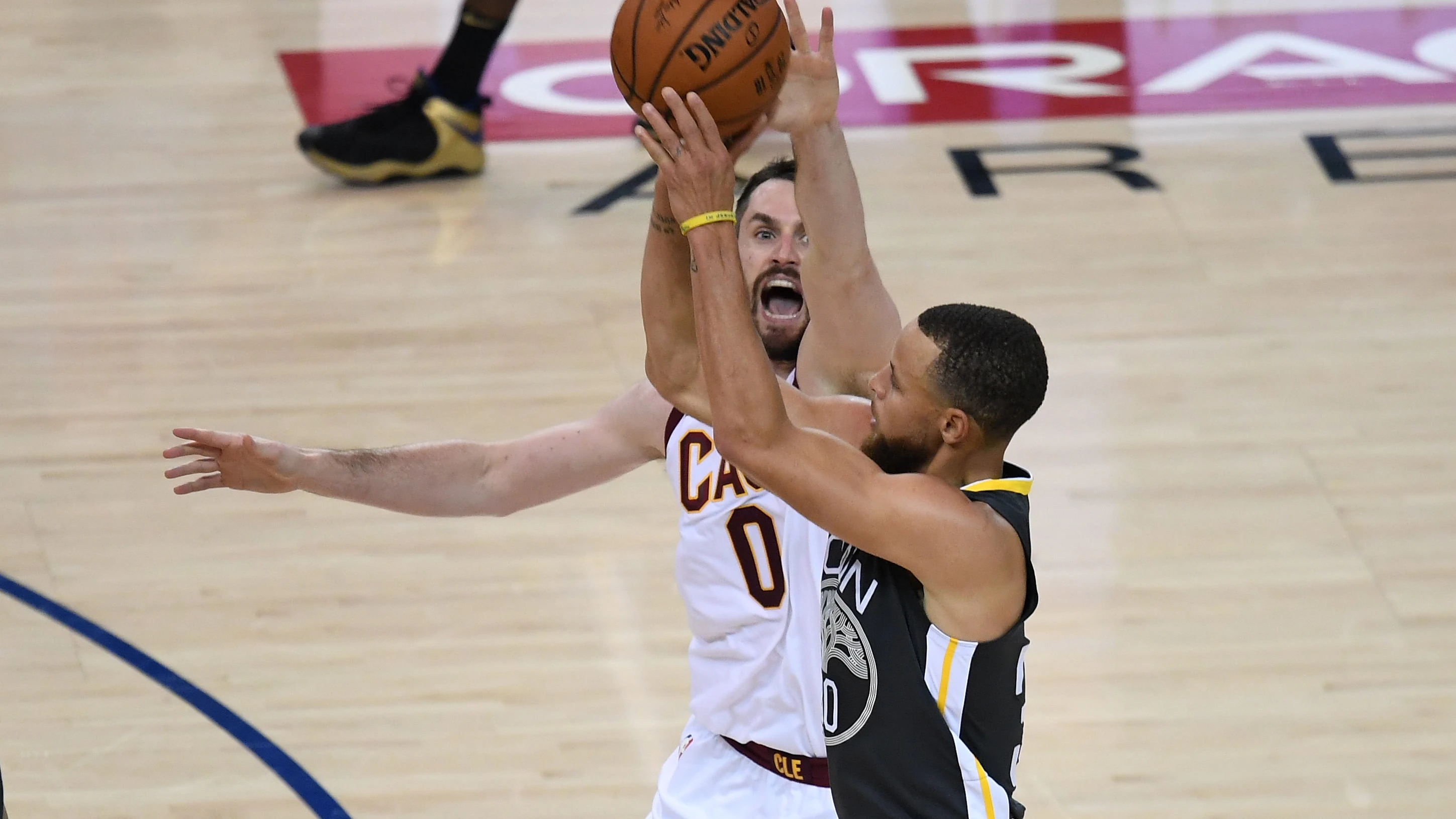 Curry lanza un triple ante la defensa de Kevin Love