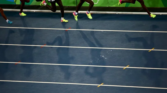 Varios atletas corren en una pista de atletismo Varios atletas corren en una pista de atletismo